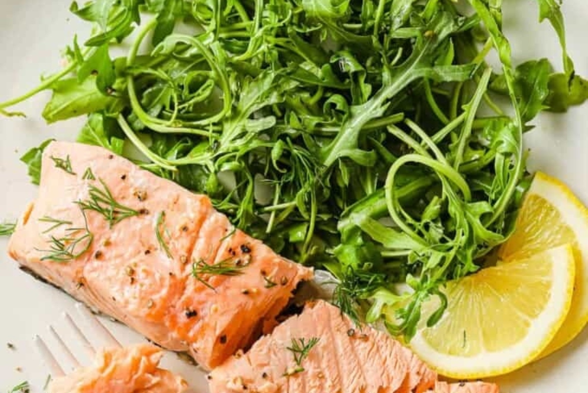 Recipe: Salmon with dill and lemon slices on a white plate.