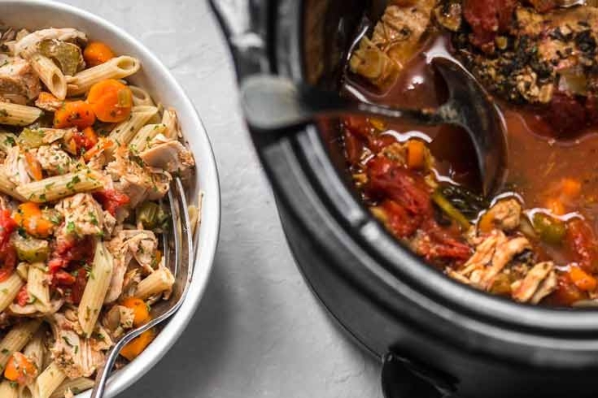 A hearty bowl of pasta and chicken simmering in a crock pot, perfect for cozy winter dinners.