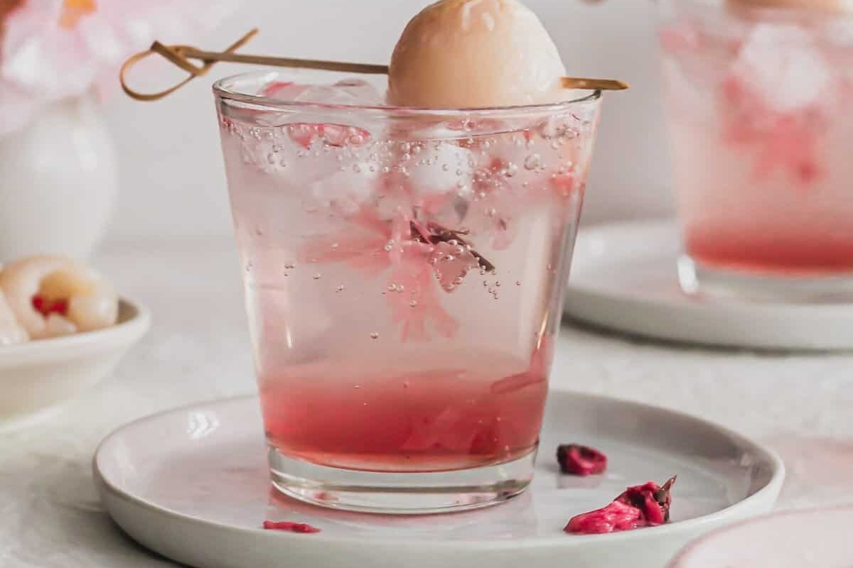 A Valentine's Day cocktail featuring a glass of pink gin with a cherry on top.