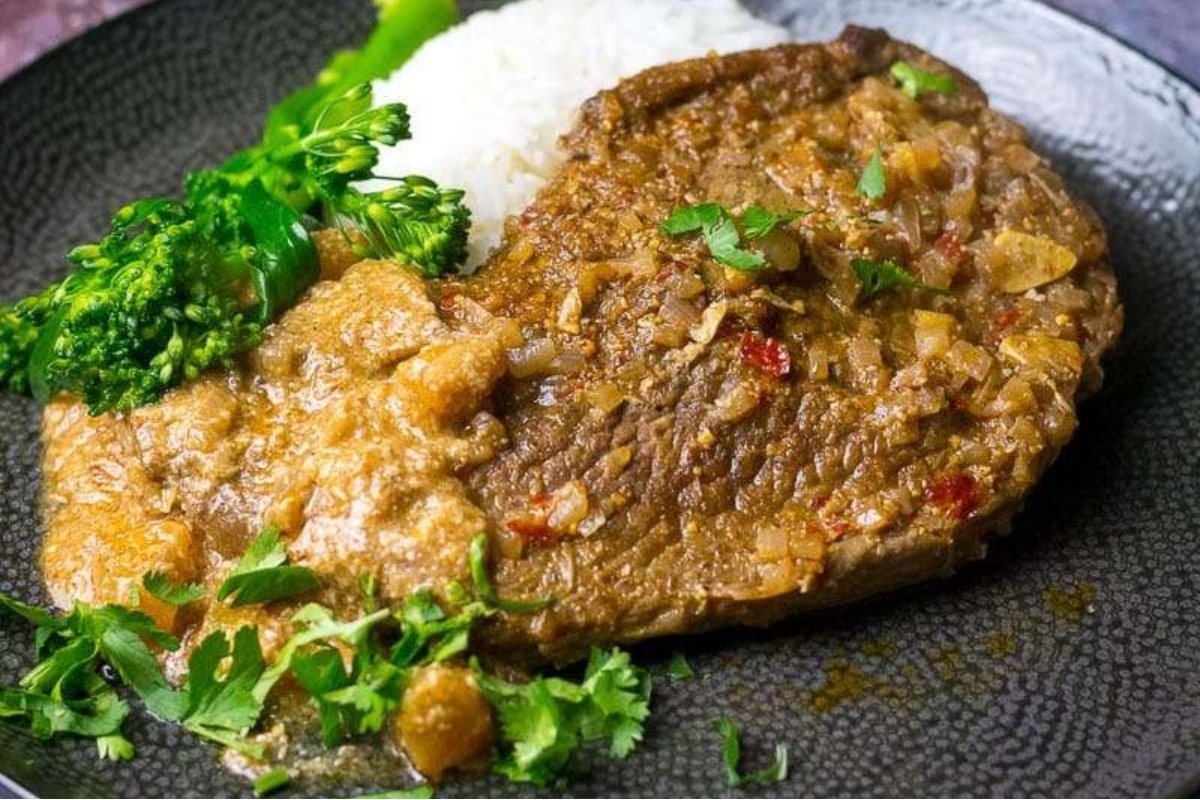 A plate with meat, rice and broccoli.