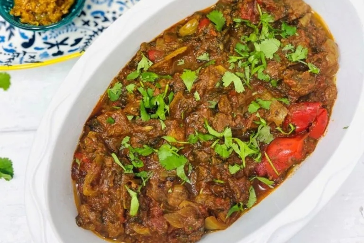 A white dish with meat and vegetables in it.