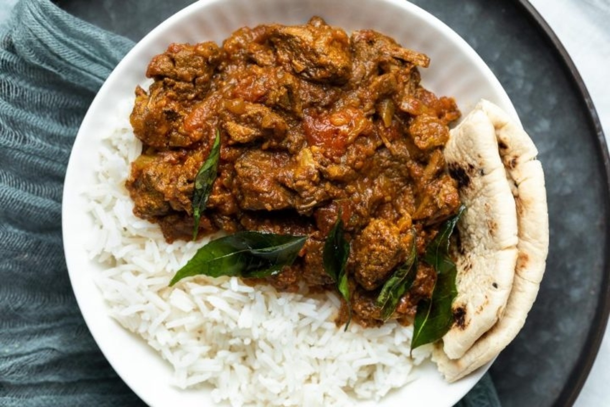 A bowl of rice and curry on a table.