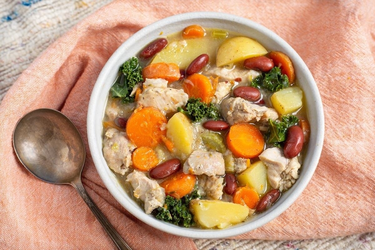 A slow cooker chicken stew with carrots, potatoes and beans.