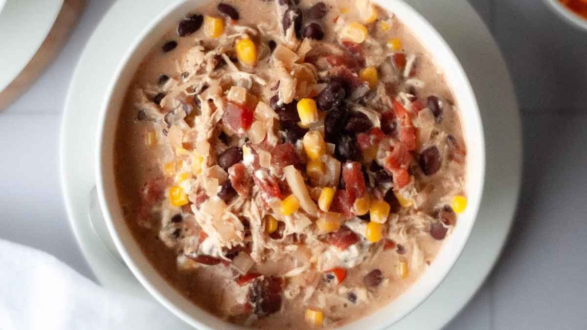 A flavorful bowl of Mexican chicken enchilada soup with corn and black beans, perfect for a quick and delicious chicken dinner.