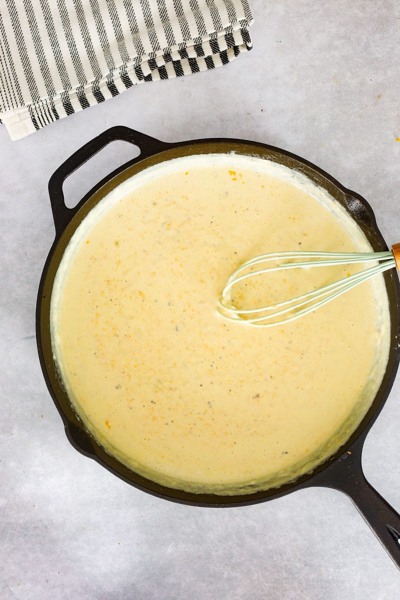 A cast iron skillet filled with mouthwatering loaded mac and cheese.