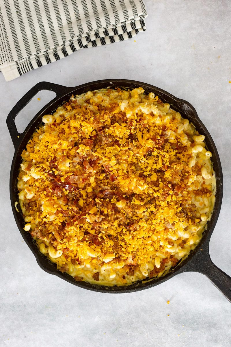 Loaded mac and cheese cooked in a cast iron skillet.