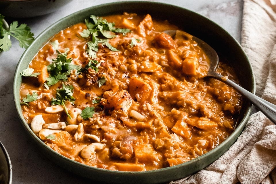 This curry recipe features a bowl of delightfully flavorful sweet potato curry, enhanced with the satisfying crunch of cashews and cashew nuts.