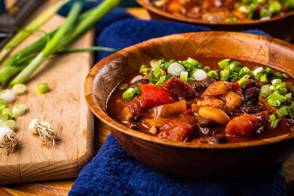 Two bowls of Slow Cooker chili on a wooden table.