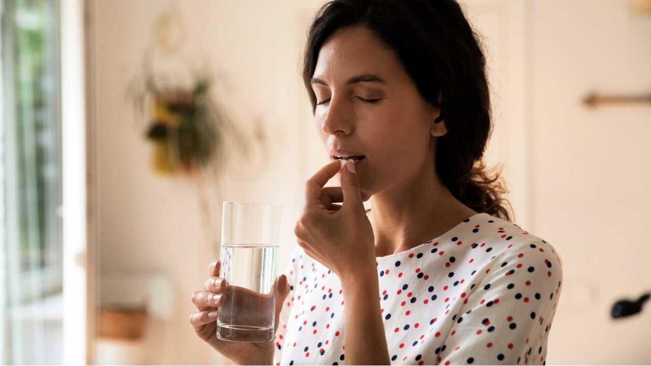 woman taking vitamin pill
