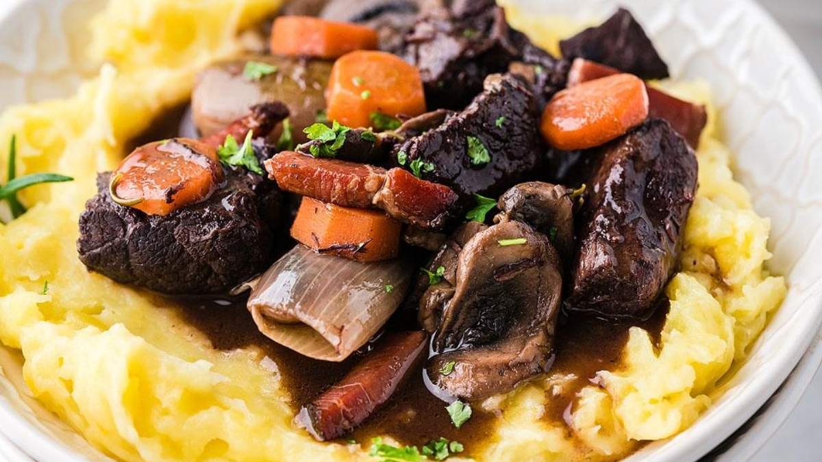 A comforting round-up of shared comfort food recipes featuring a bowl of stew with carrots, mushrooms, and mashed potatoes.