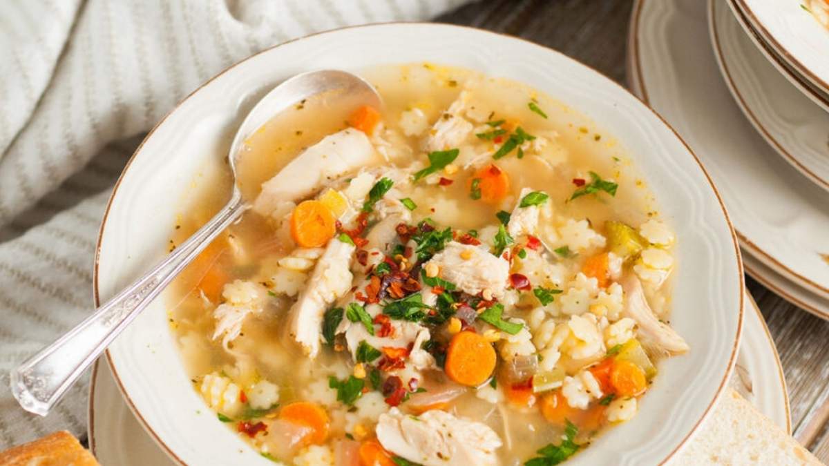 This shared recipe round-up features a delicious bowl of chicken noodle soup with carrots, served alongside warm bread.