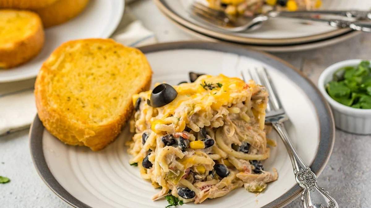 Chicken enchilada casserole, a comforting and shared recipe, served on a plate with bread.