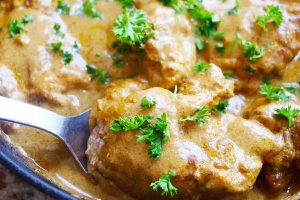 Winter dinner of chicken curry simmered in a skillet, served with a spoon.