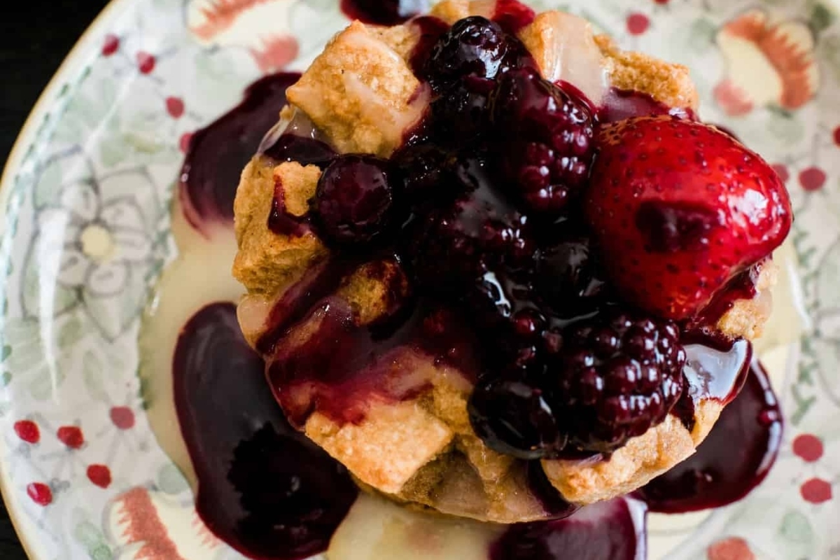 A waffle with berries and syrup on a plate.