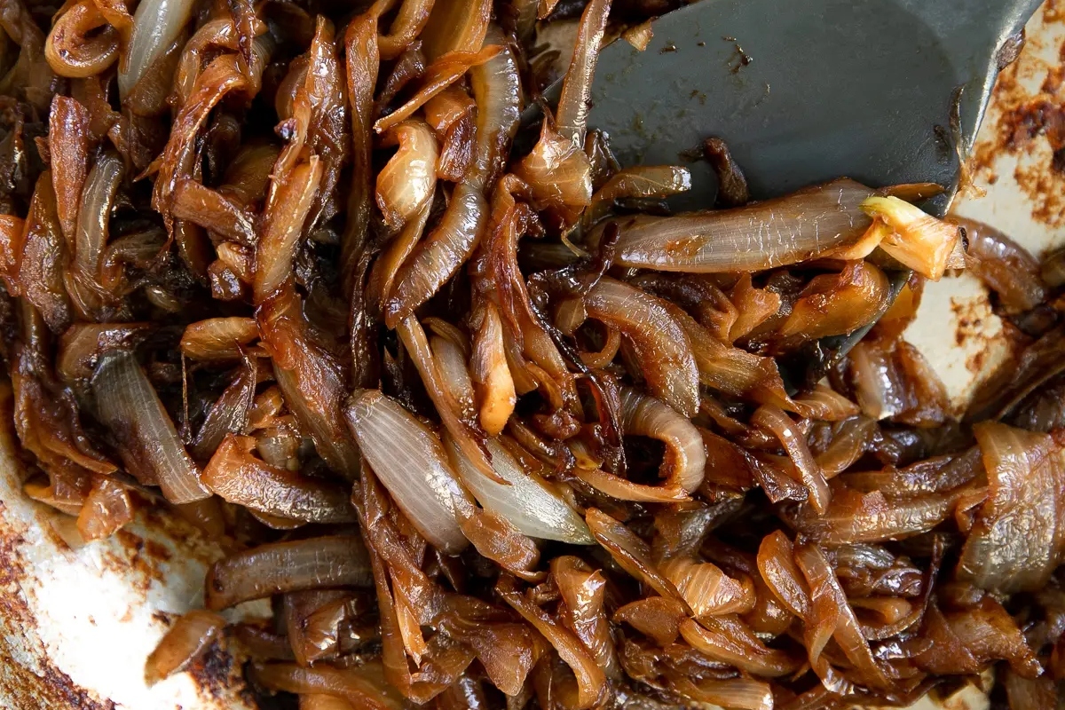 Onions in a pan with a fork.