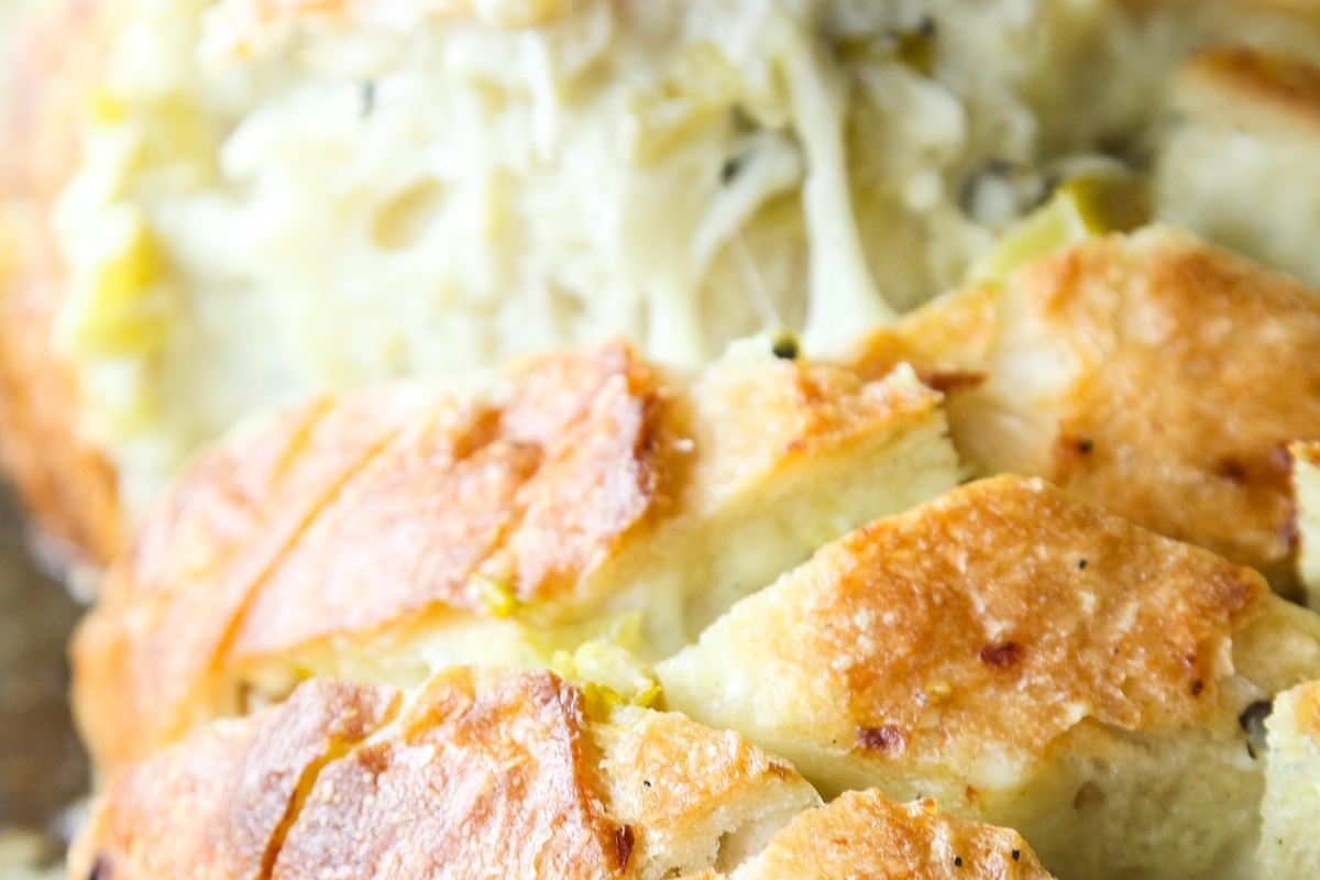 A close up of a piece of bread with cheese on it.