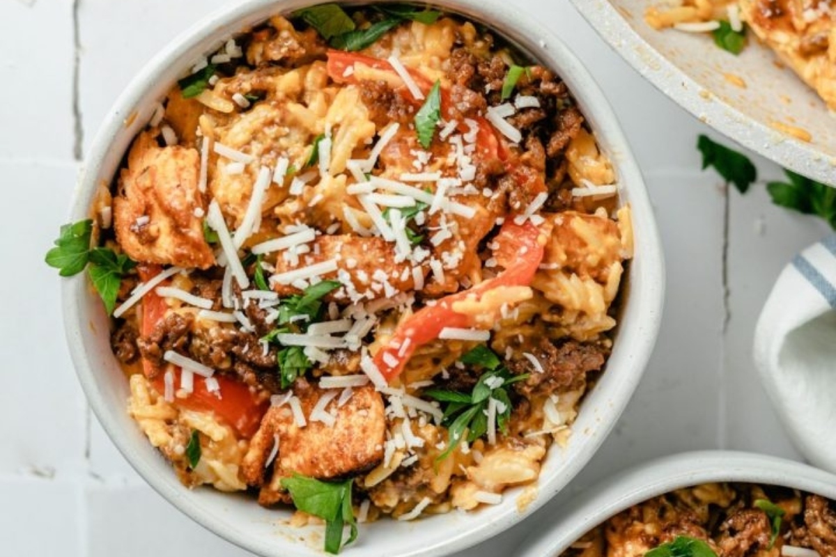 A bowl of meat and rice with parmesan on top.