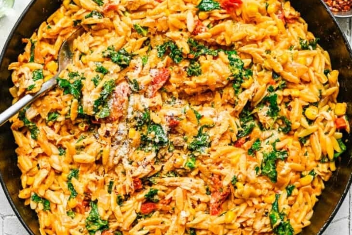 A skillet filled with pasta and spinach.