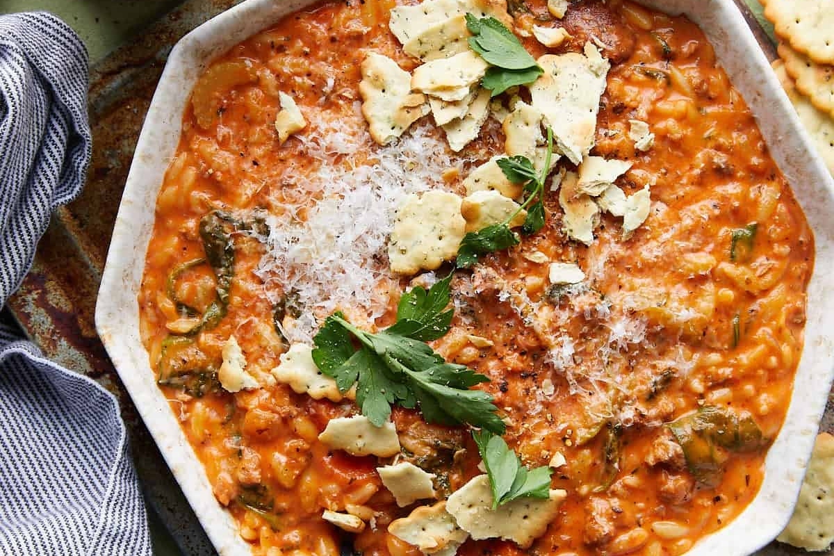 A white dish with a bowl of pasta and crackers.