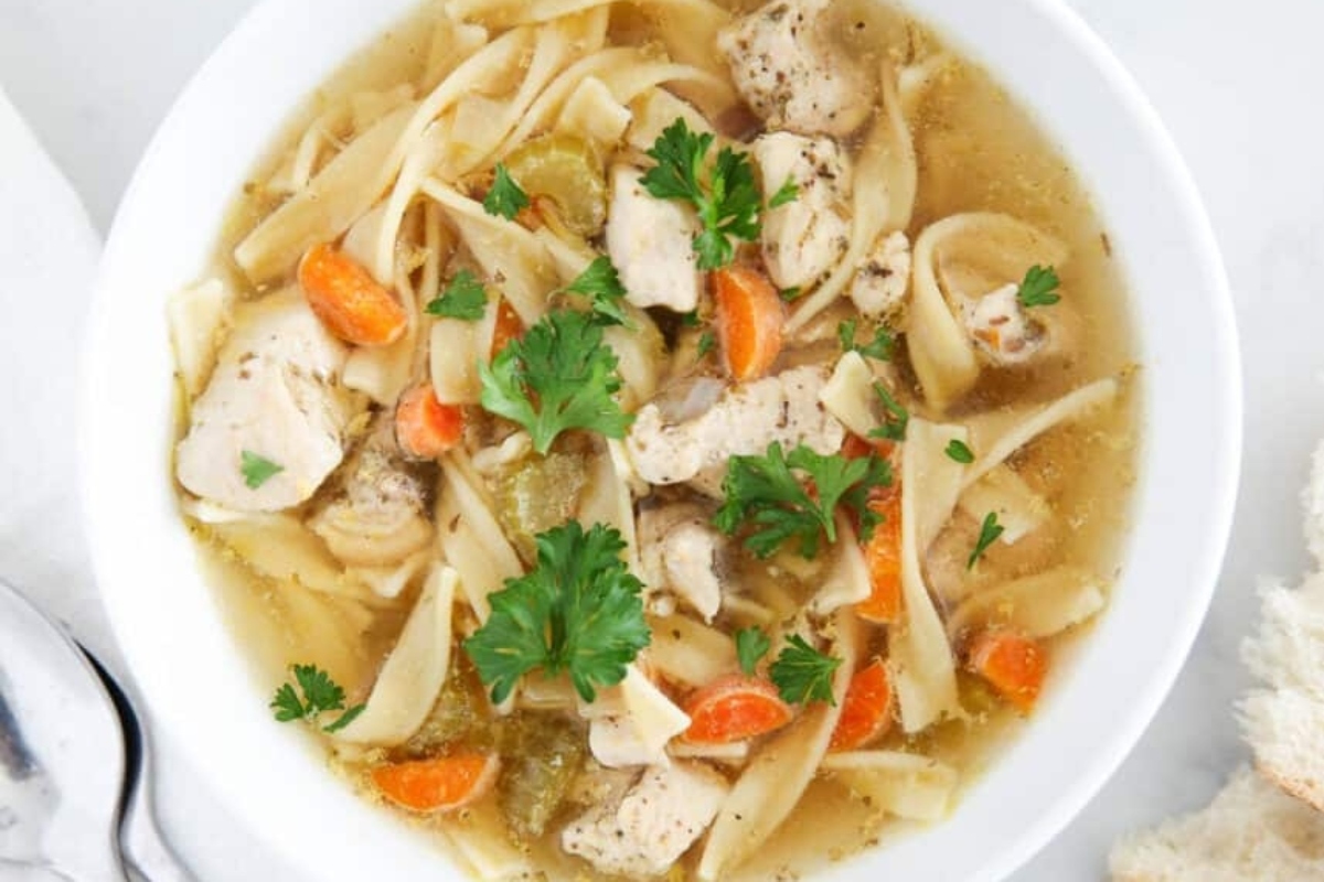 Chicken noodle soup in a white bowl.