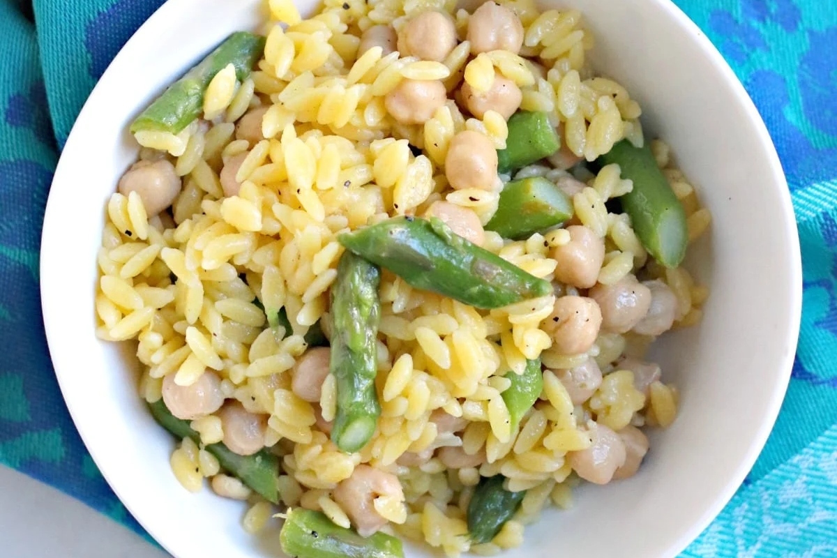 A bowl of rice with asparagus and chickpeas.