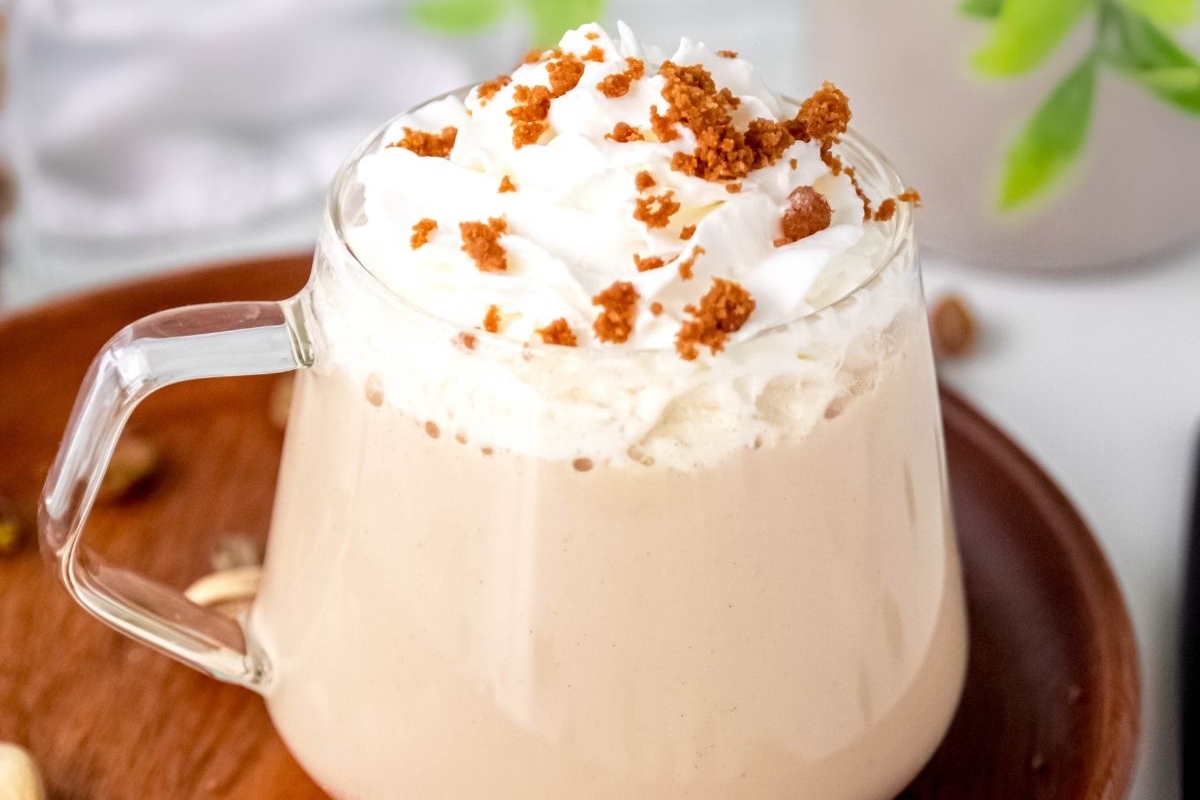 A cup of coffee with whipped cream and nuts.