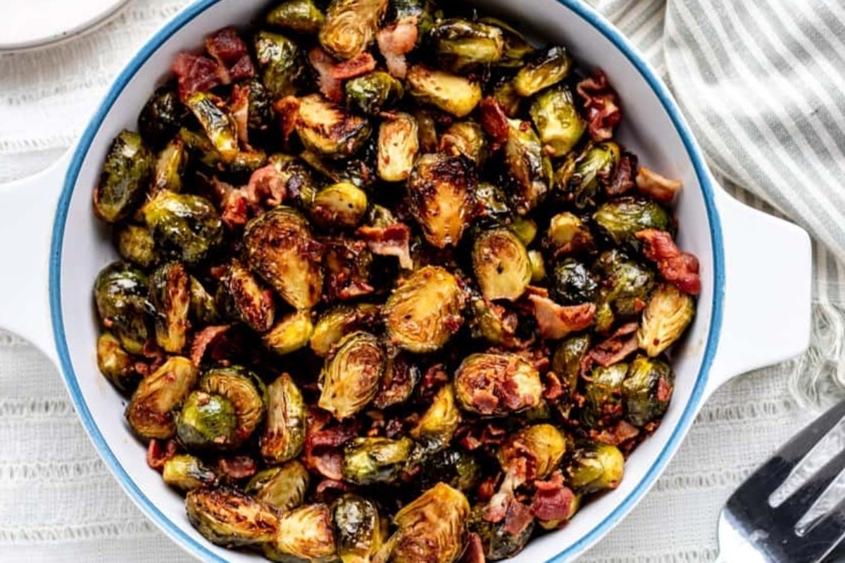 Roasted brussels sprouts with bacon in a white bowl.