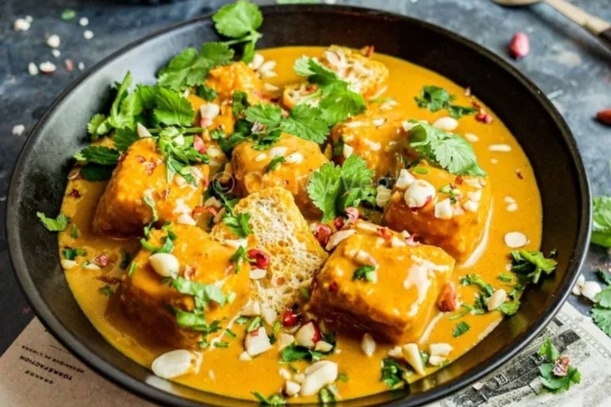 A bowl of curry with tofu in it.