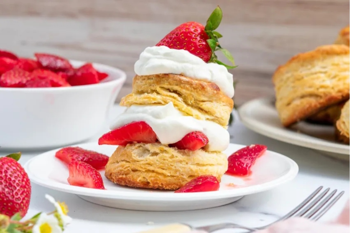 Strawberry scones with whipped cream and strawberries on a plate.