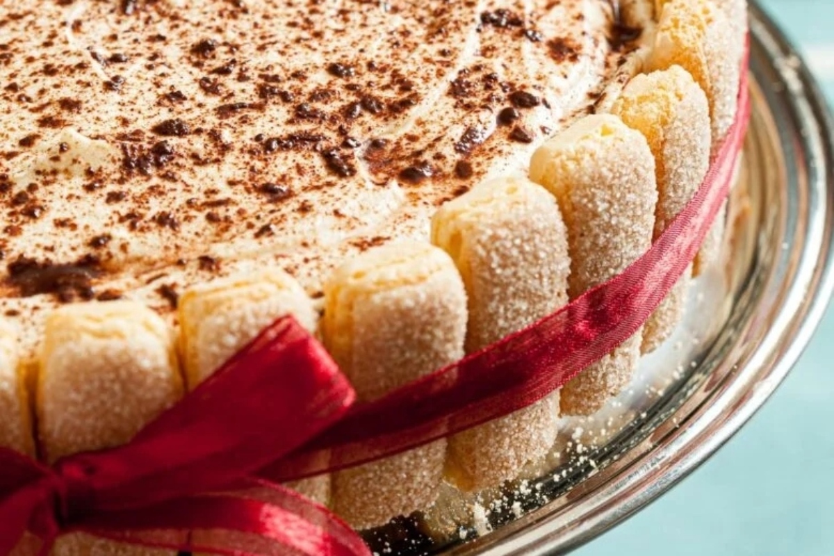 A cake with a red ribbon on top.