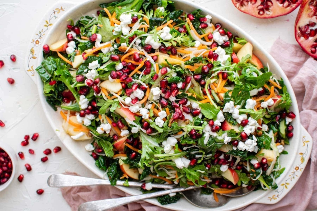 Pomegranate kale salad with feta cheese and pomegranate seeds.