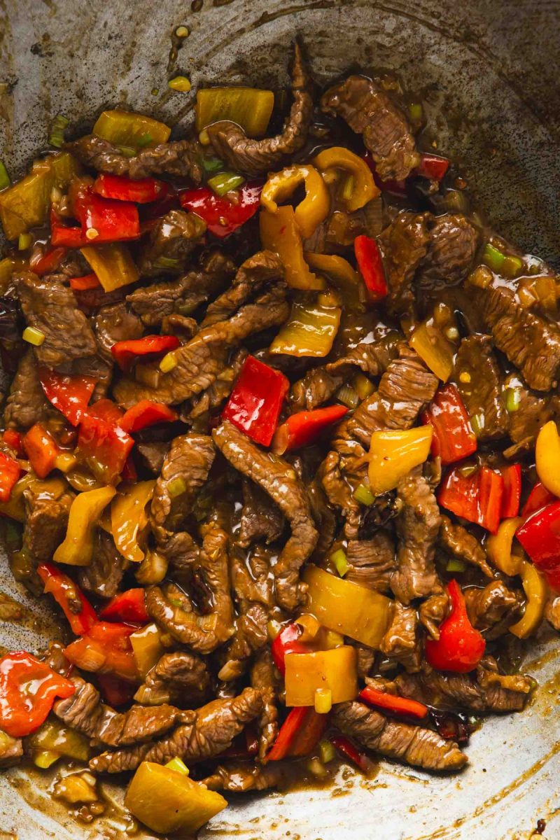 Kung Pao beef stir fry with peppers and peanuts in a wok.