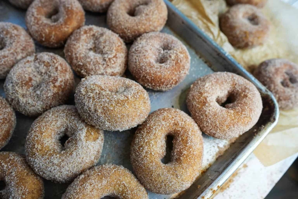 Sugared doughnuts on a baking sheet.