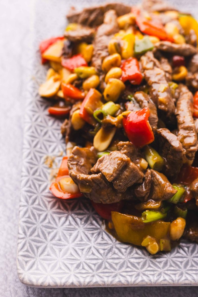 Kung pao beef stir fry with peppers and peanuts on a plate.