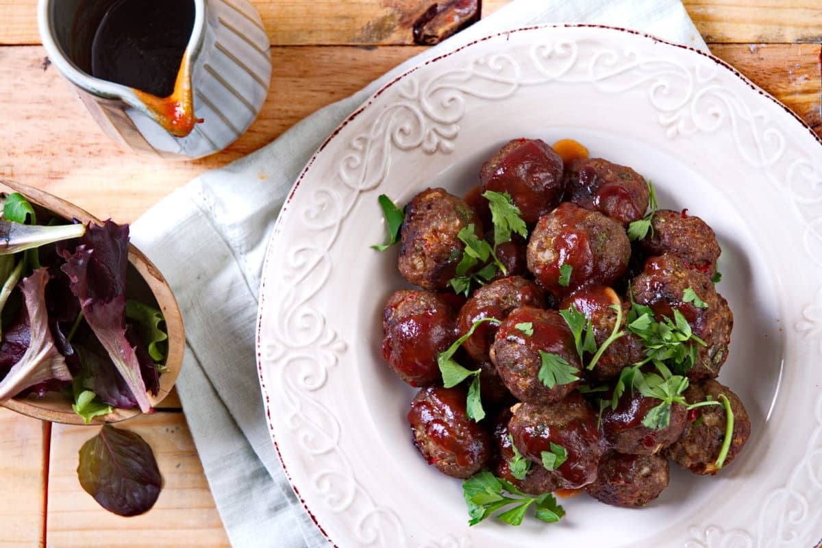 A plate of meatballs with a sauce on it.