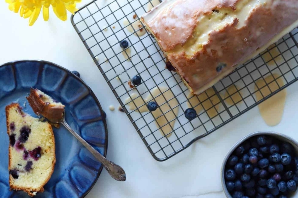A slice of blueberry pound cake on a cooling rack.