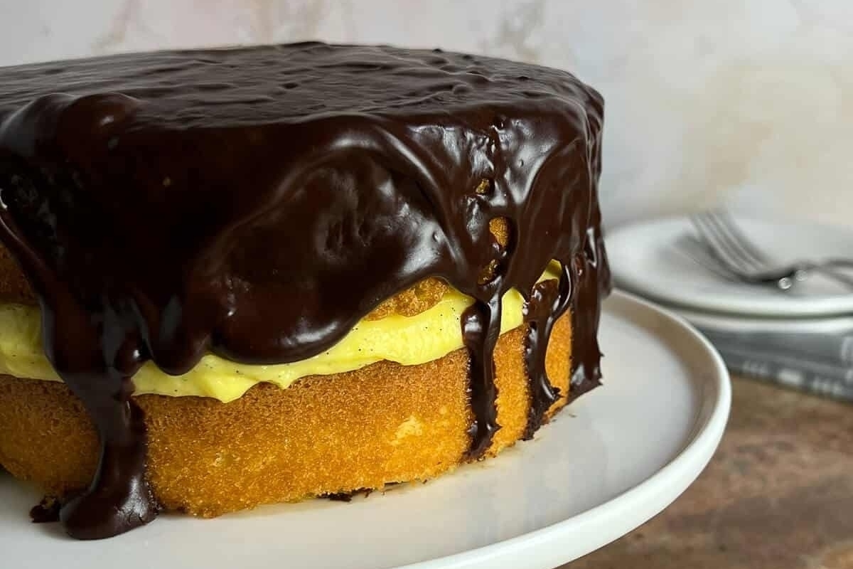 A cake with chocolate icing on a plate.