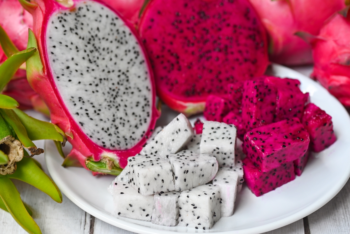 Dragon fruit slice on white plate with pitahaya background.
