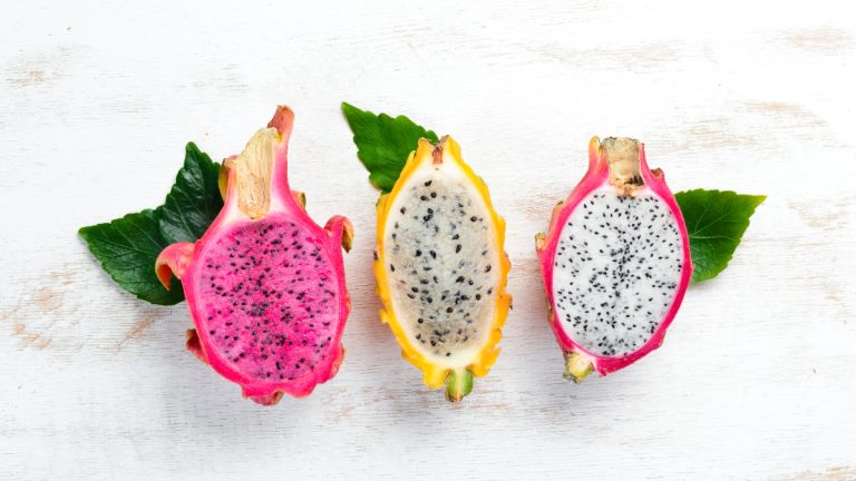Three dragon fruit on a white background, showcasing their vibrant colors and unique appearance.