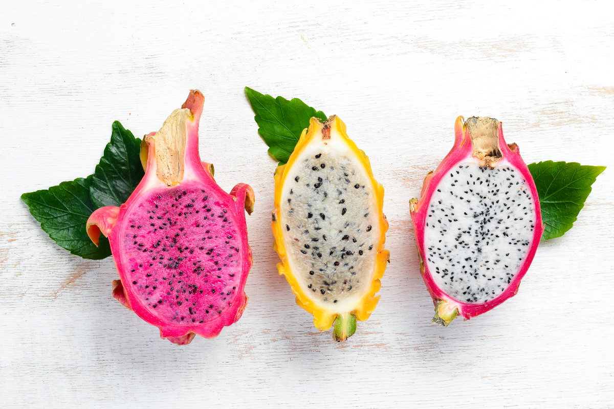 Three dragon fruit on a white background, showcasing their vibrant colors and unique appearance.