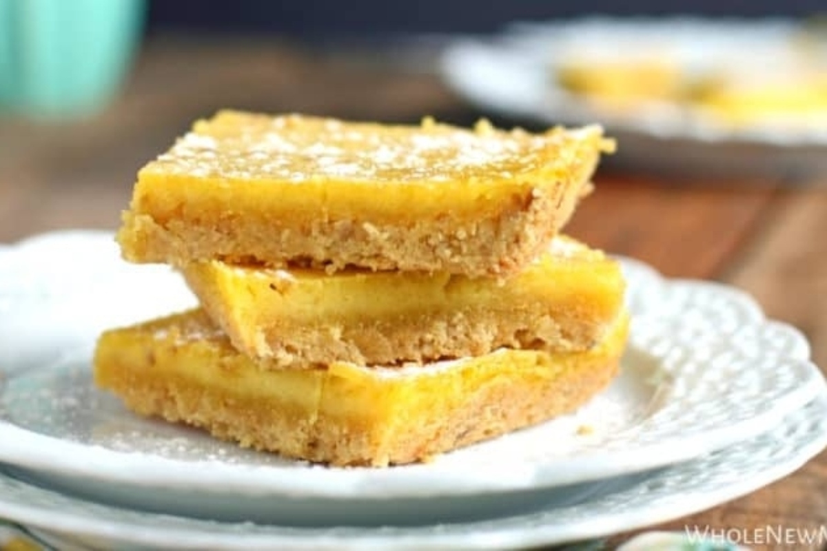 Lemon bars on a plate with powdered sugar.