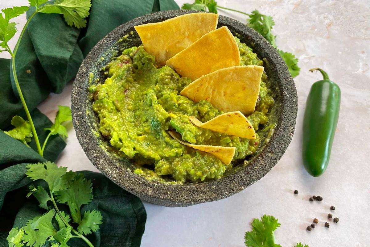 Guacamole in a bowl with tortilla chips.