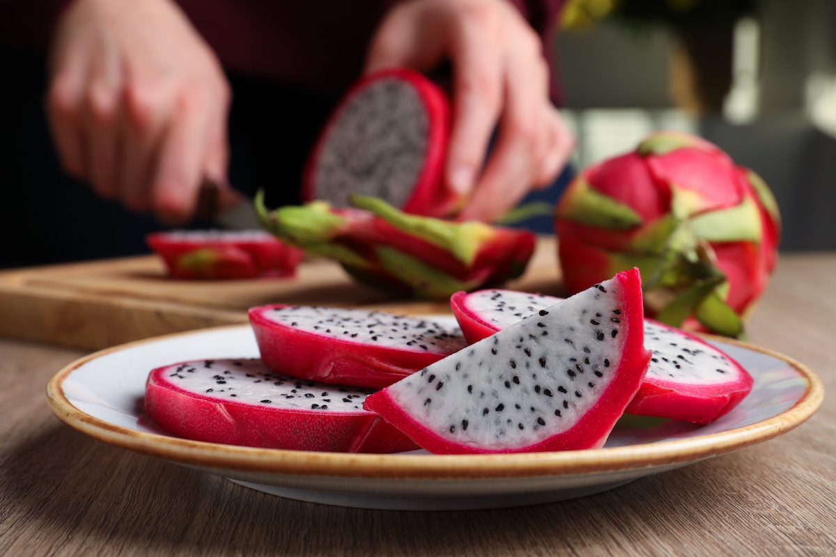 Plate with delicious cut white dragon fruit on wooden table indoors, closeup