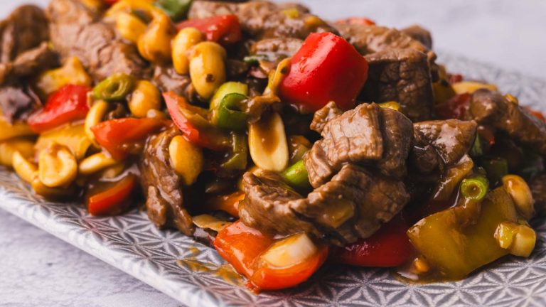 Kung pao beef stir fry with peppers and peanuts on a plate.