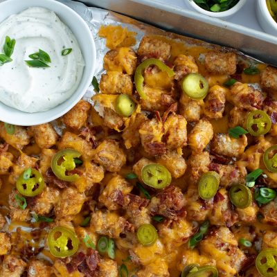 A tray of loaded tater tots with cheese, bacon and jalapenos.