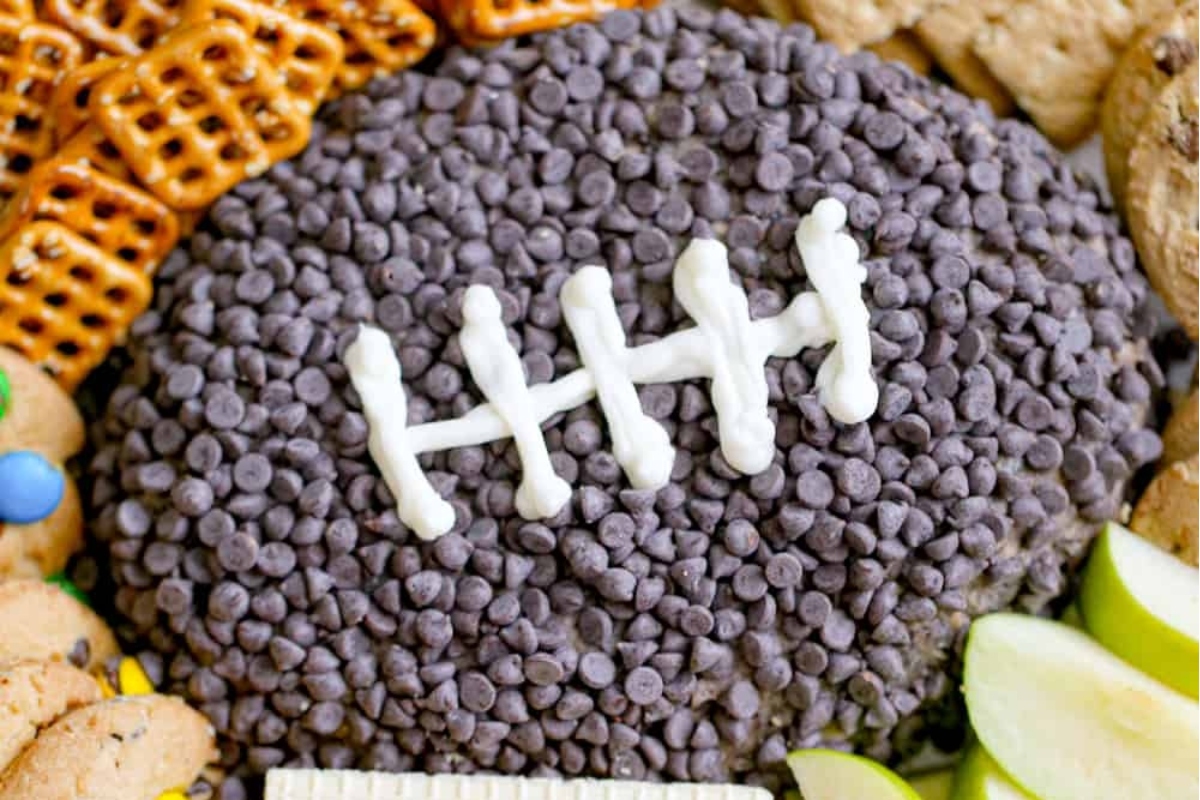 A football shaped cookie with chocolate chips and pretzels.