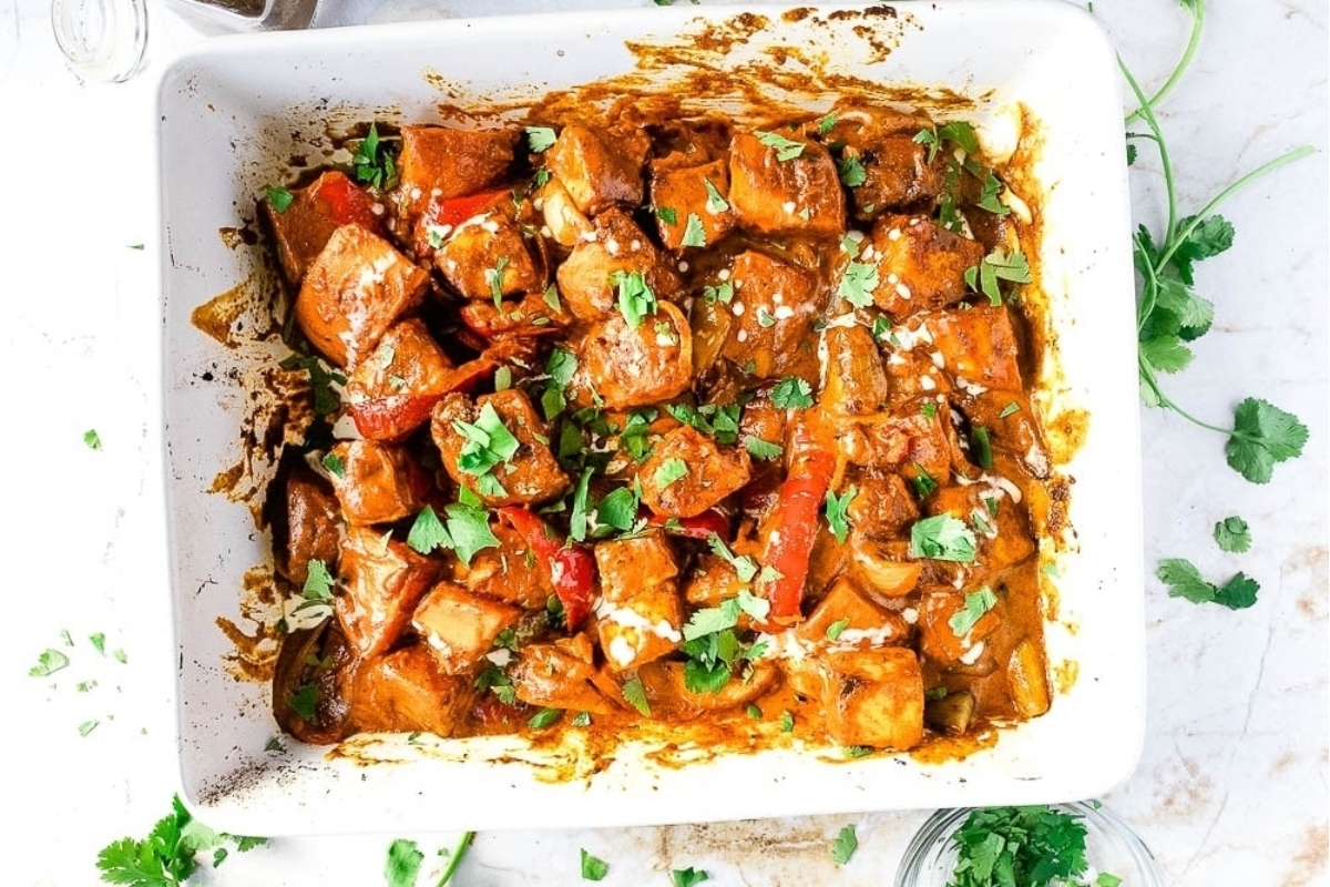 A casserole dish with chicken and peppers in it.
