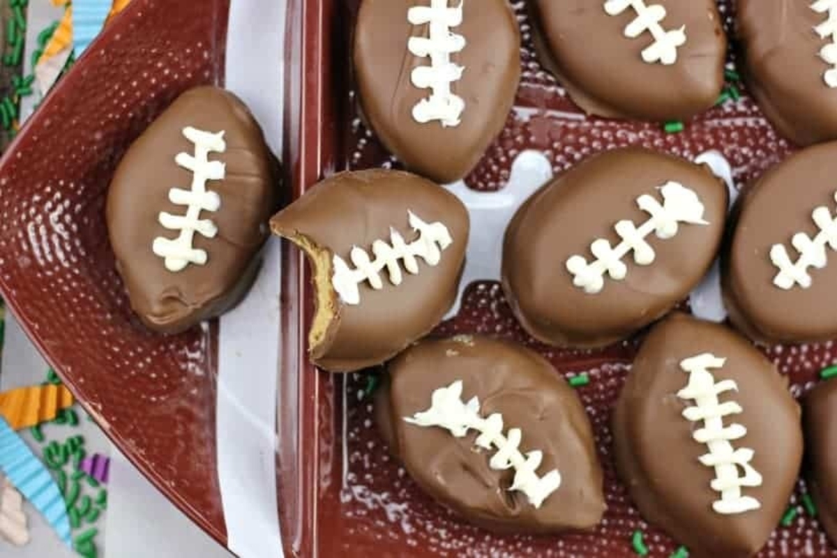 Chocolate covered football cookies on a plate.