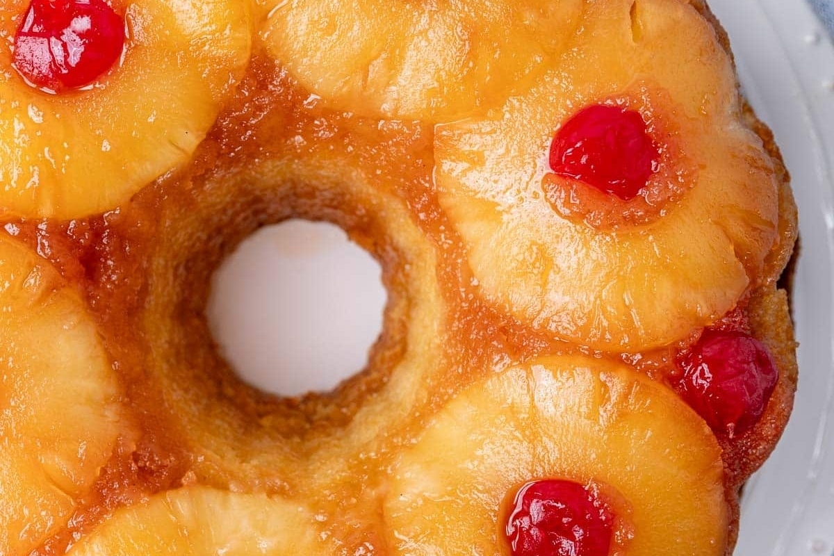 A pineapple upside down cake with cherries on top.