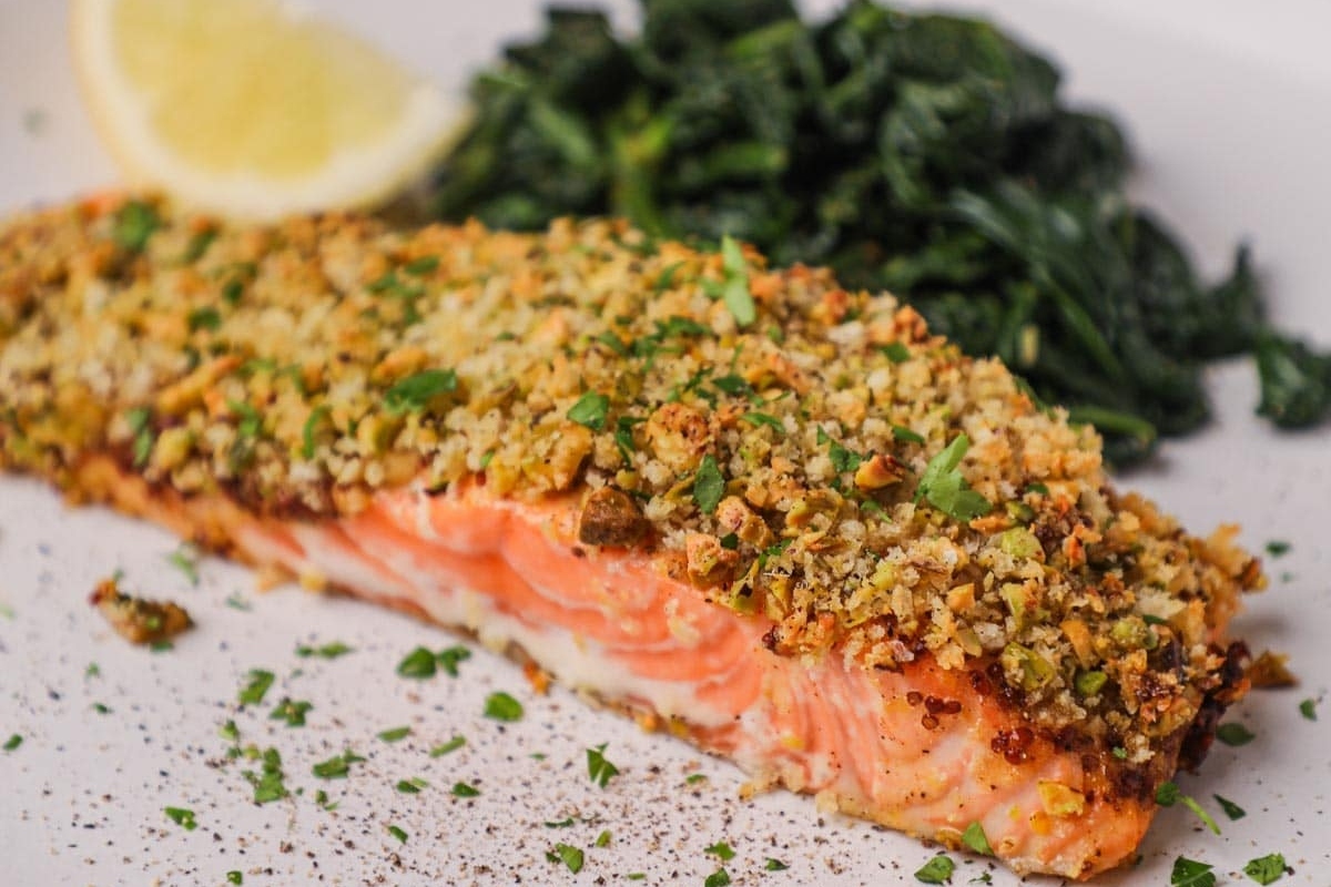 A plate with salmon and greens on it.